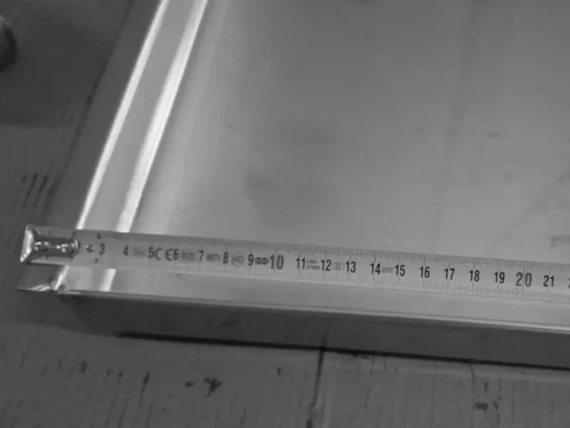 Detaliu care prezintă măsurarea șinei pentru tava profesională din inox alimentar AISI 304. Imaginea ilustrează utilizarea unei rulete pentru a confirma dimensiunea tehnică a șinei pe lățime, subliniind precizia execuției produsului.