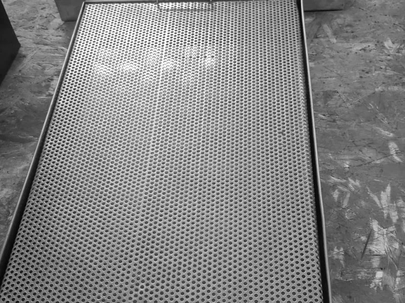 Vedere de sus a suprafeței perforate a tăvii pentru scurgerea paharelor, fabricată din inox AISI 304. Acest design asigură o drenare rapidă și eficientă a apei, fiind un echipament ideal pentru utilizarea intensivă în baruri, restaurante și bucătării profesionale HoReCa.