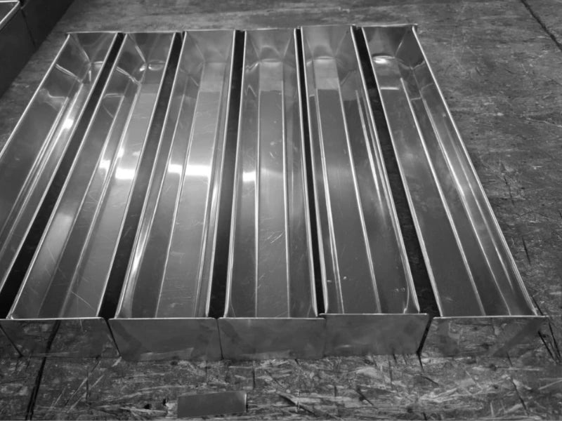 Set de forme pentru terine din inox, lucrate profesional în fabrica din România, aliniate pe bancul de lucru.