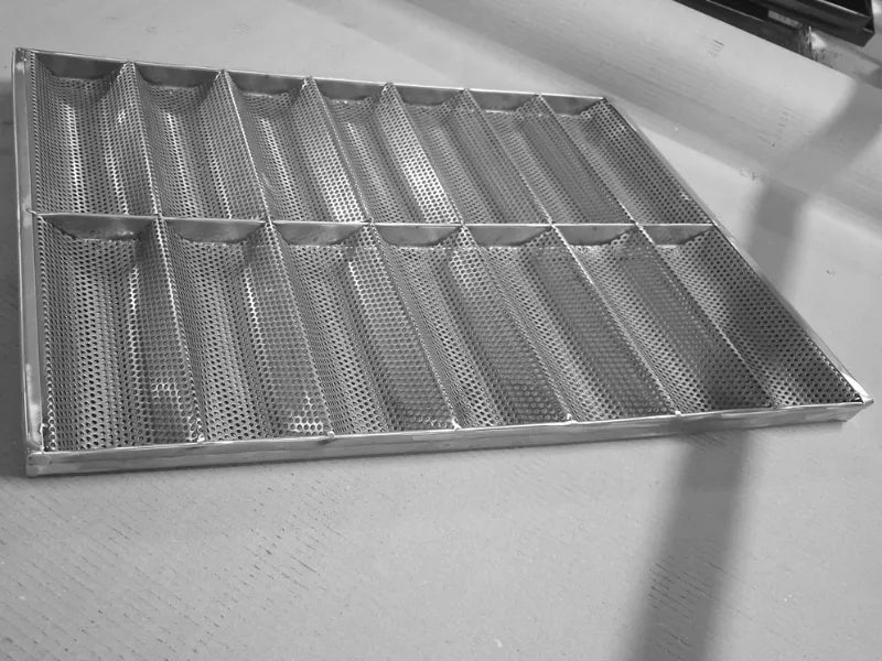 Echipament profesional de panificație: tavă perforată din inox AISI 304 pentru baghete și chifle. Formă robustă cu 14 canale și dimensiuni standard de 600x400 mm, ideală pentru coacere intensivă în brutării și patiserii comerciale.