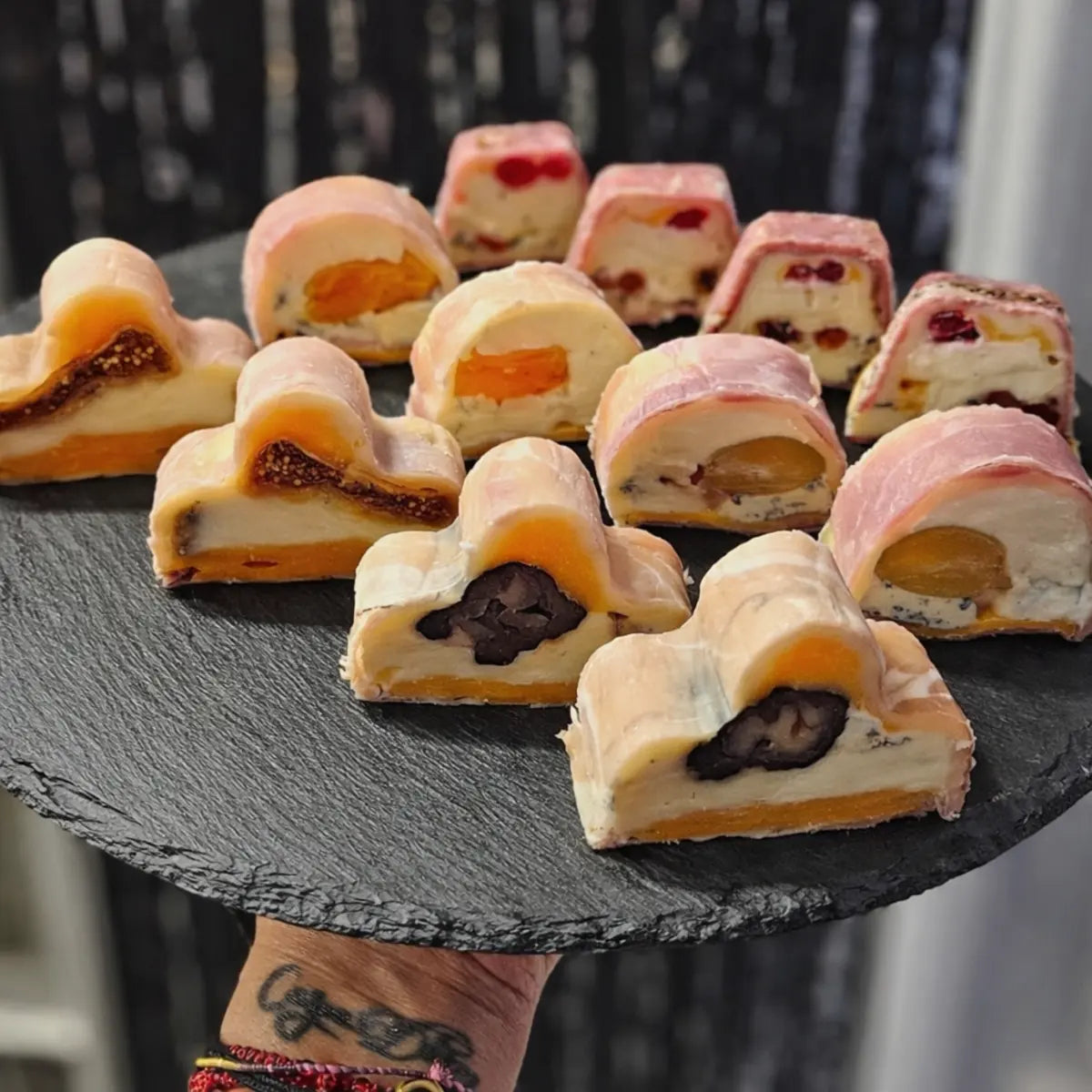 Feliuțe de terină gourmet cu design în formă de nor, așezate pe un platou negru din ardezie, pregătite într-o formă profesională din inox.
